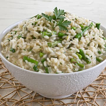 risotto with asparagus and a green garnish in a white bowl