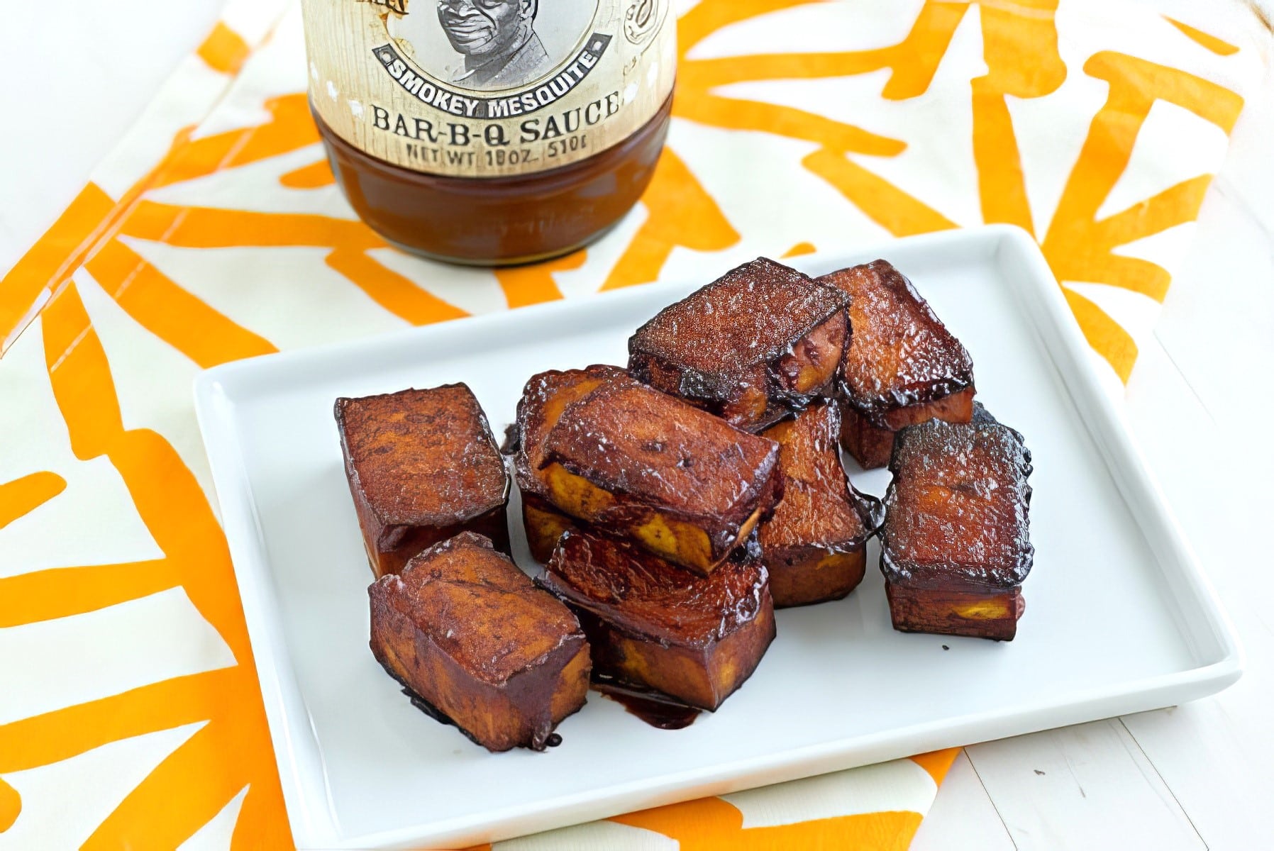 baked barbecue tofu being served on a white plate