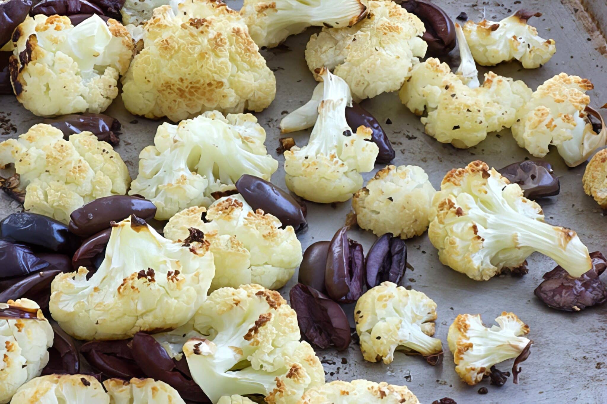 cauliflower and olives on baking sheet