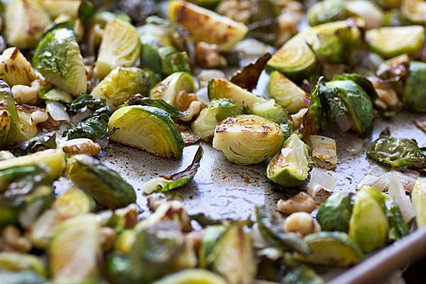Roasted Brussels Sprouts with Shallots & Walnuts on a baking sheet