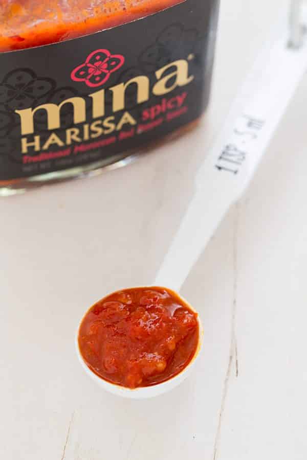 Mina Harissa hot sauce in a spoon with jar in background