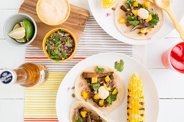 Beer-Marinated Grilled Mushroom Tacos with Pepita Relish & Chipotle Crema Recipe sitting on white plate