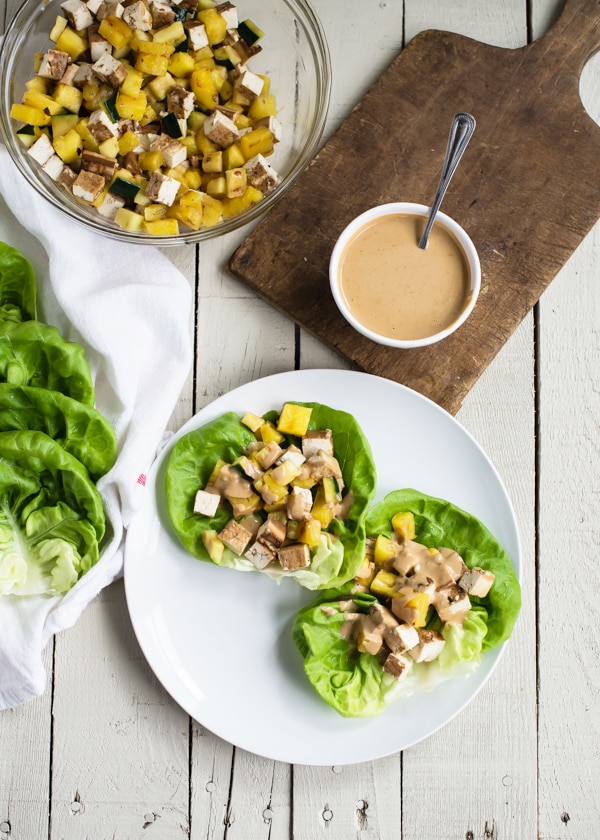 Grilled Teriyaki Tofu Lettuce Wraps with Creamy Sesame Dressing being served on a white plate