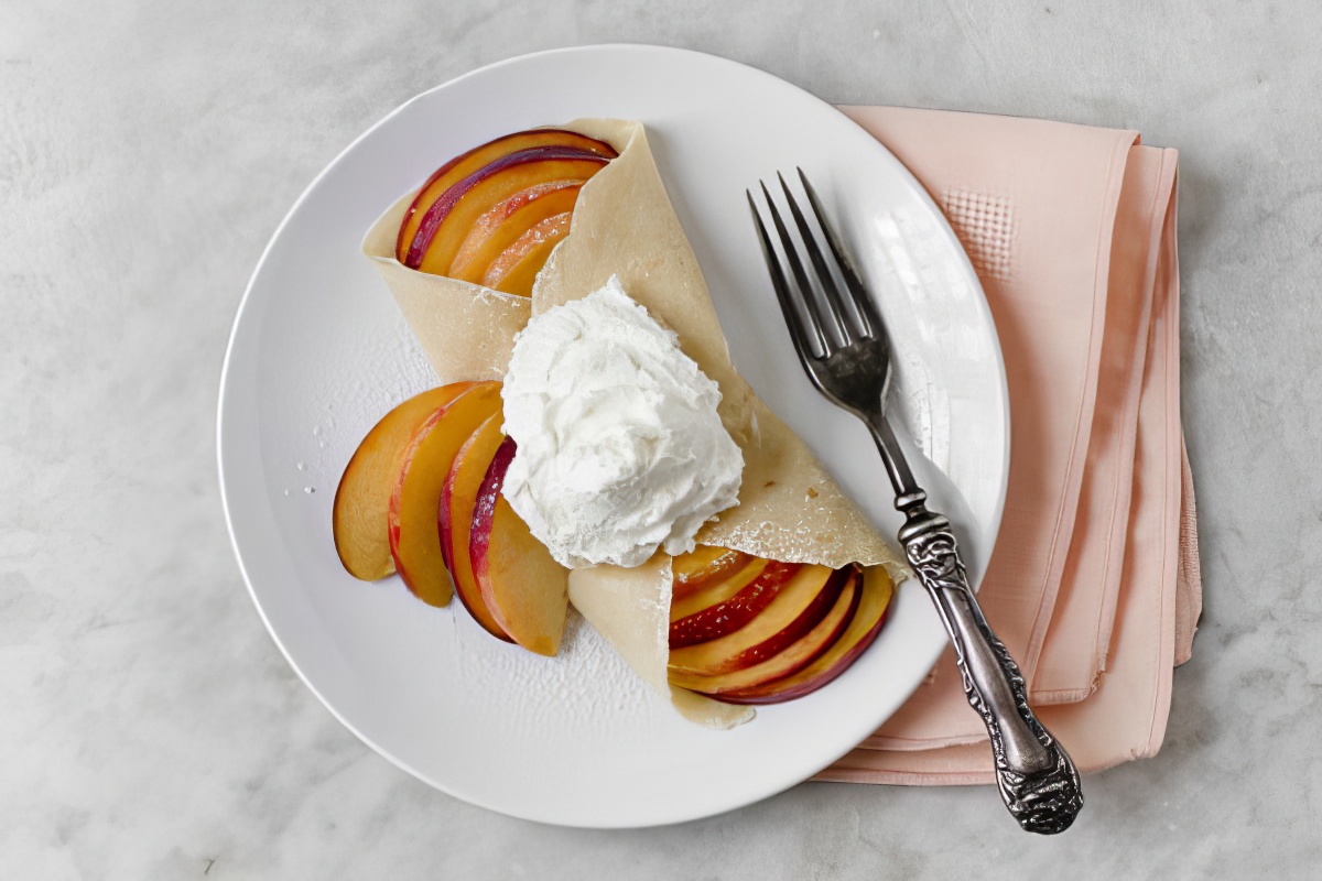 homemade crepes stuffed with fruit and topped with whipped cream