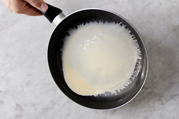 swirling crepe batter in a pan