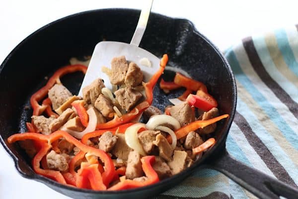 Cooking Seitan in pan with red peppers