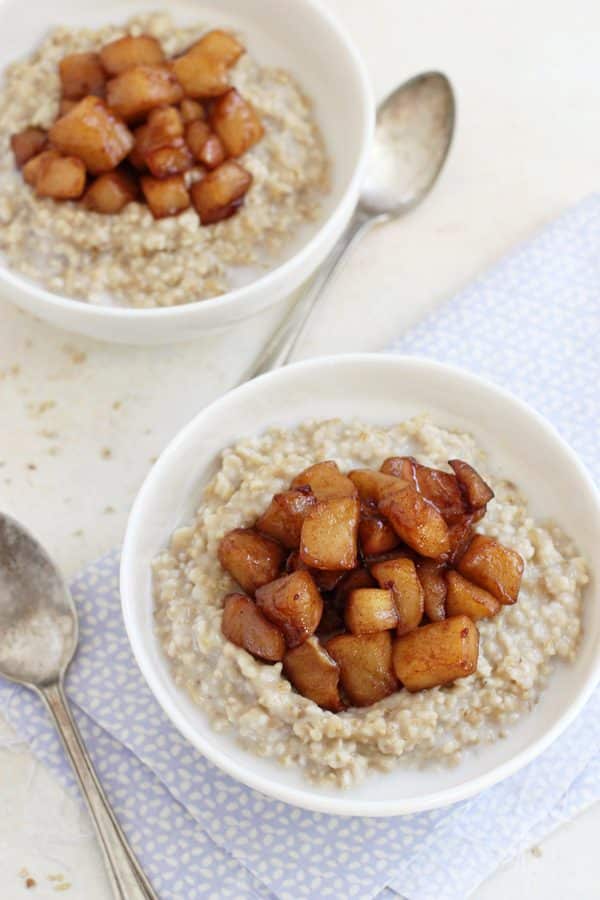 Overhead view of two bowls of apple ginger steel-cut oats topped with caramelized cinnamon apples