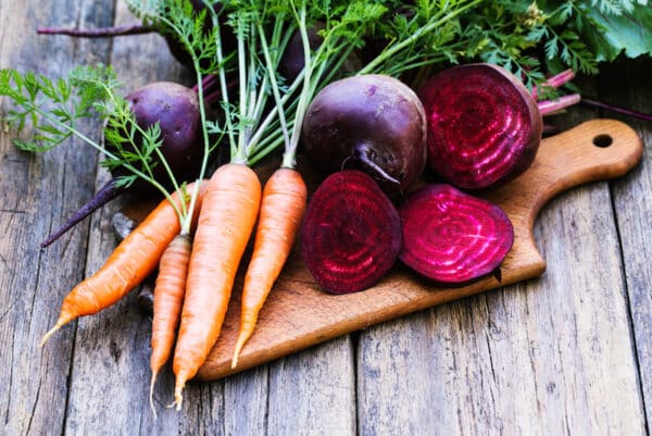 fresh beet and carrots on wooden background