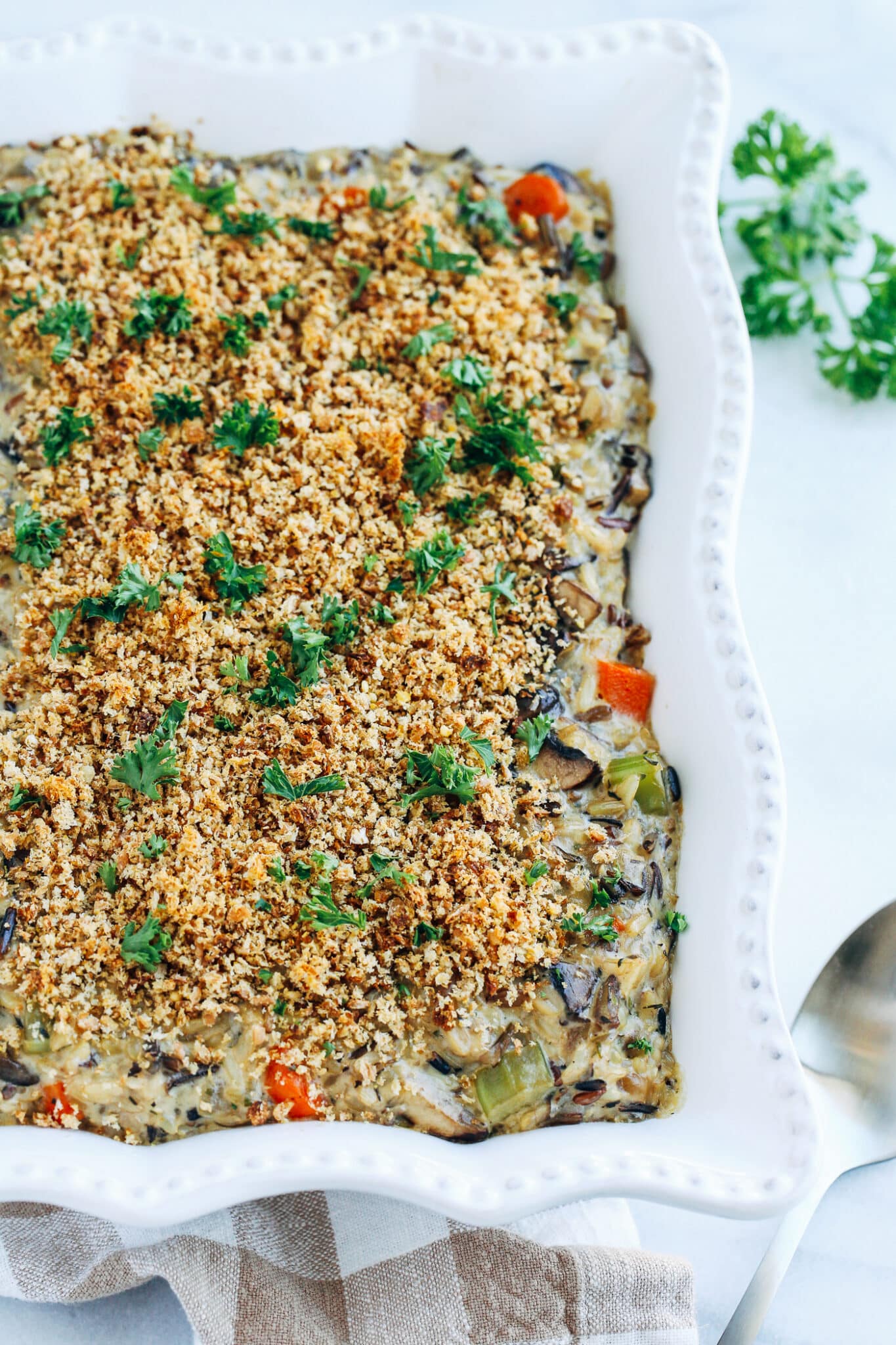 close up of Creamy Wild Rice and Mushroom Casserole in white baking dish