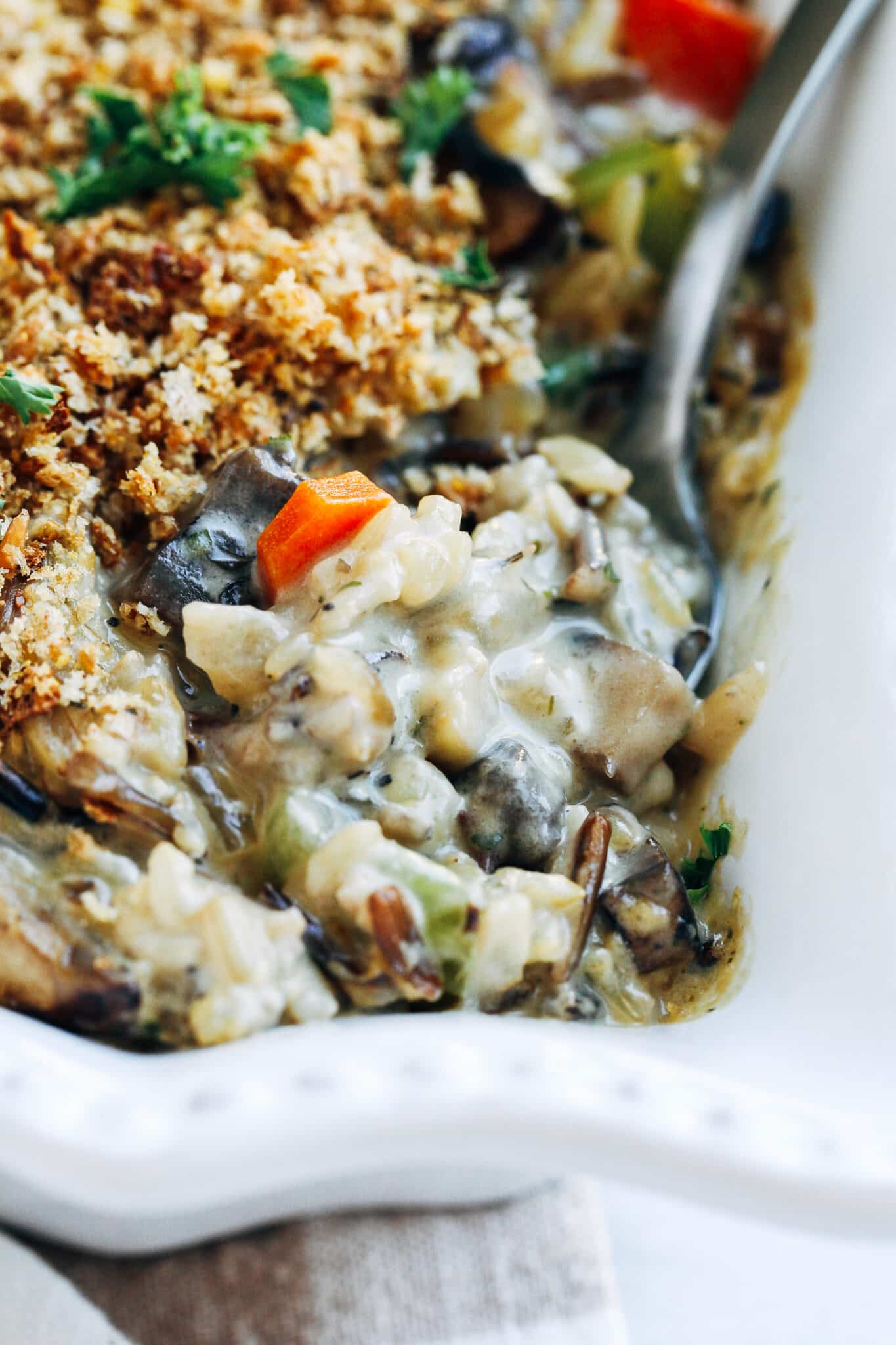scooping out a serving of Creamy Wild Rice and Mushroom Casserole