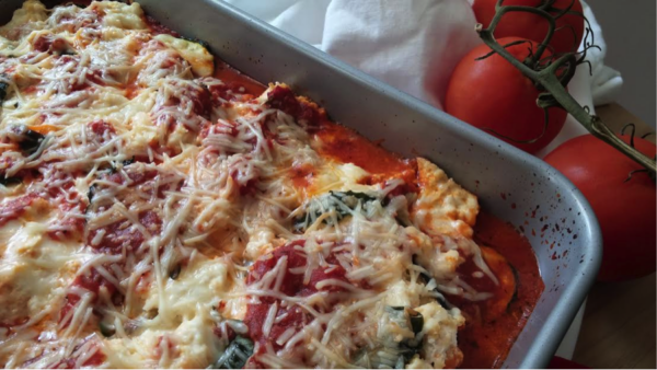 eggplant parmesan in pan with melted cheese and whole tomatoes on the vine