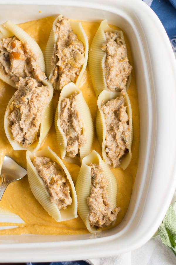 butternut squash stuffed shells being served in a casserole dish