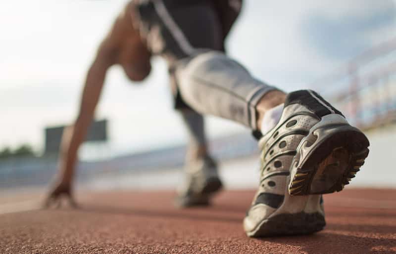 Athlete runner feet running on treadmill closeup on shoe.