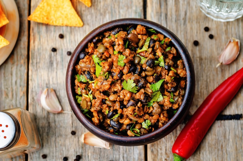 vegetarian chili with cilantro on a dark wood background. the toning. selective focus