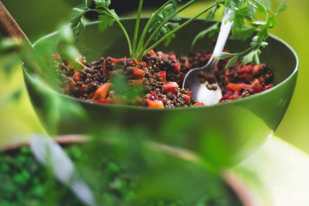 lentils and red peppers with cilantro in green bowl