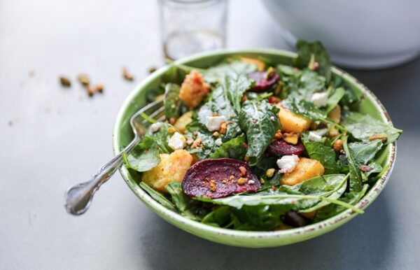 beets and goat cheese over mixed greens in a bowl