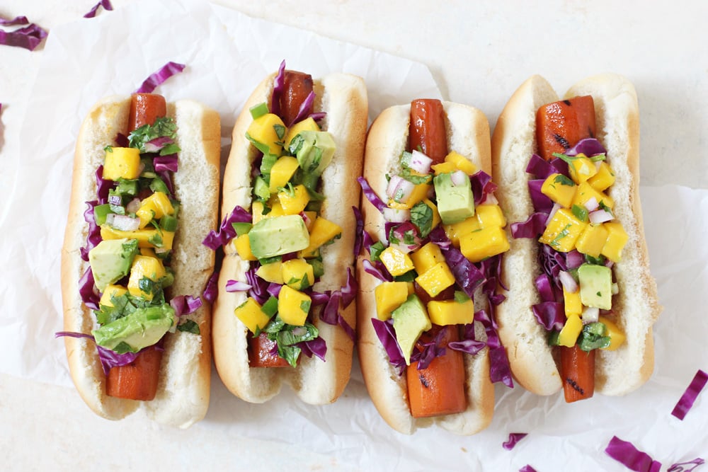 four vegan carrot dogs topped with mango salsa