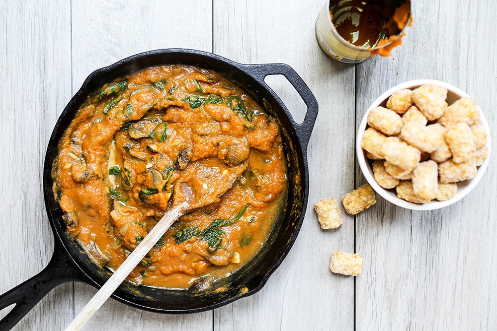 Pumpkin, Mushroom, and Spinach Tater Tot Casserole being prepared in a skillet