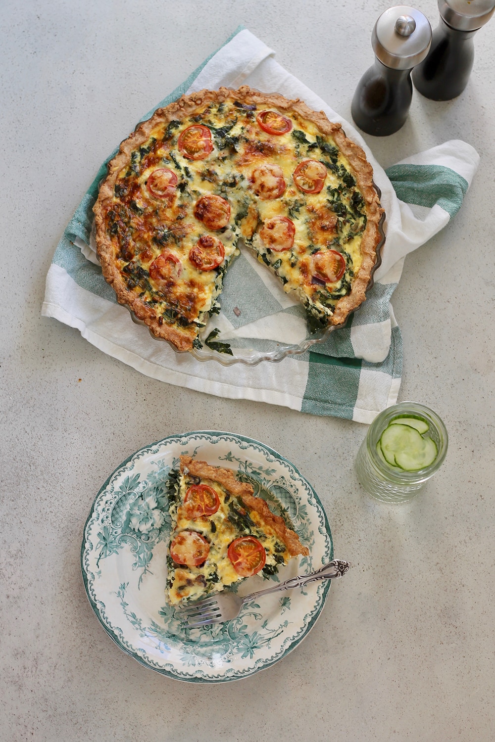 a slice of Kale Quiche with Cherry Tomatoes, Corn & Sharp Cheddar being served