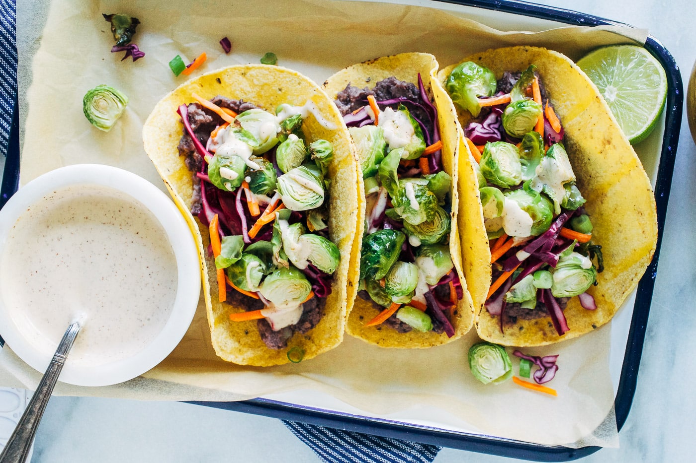 tray of 3 Roasted Brussels Sprout Tacos with small bowl of Chipotle Aioli