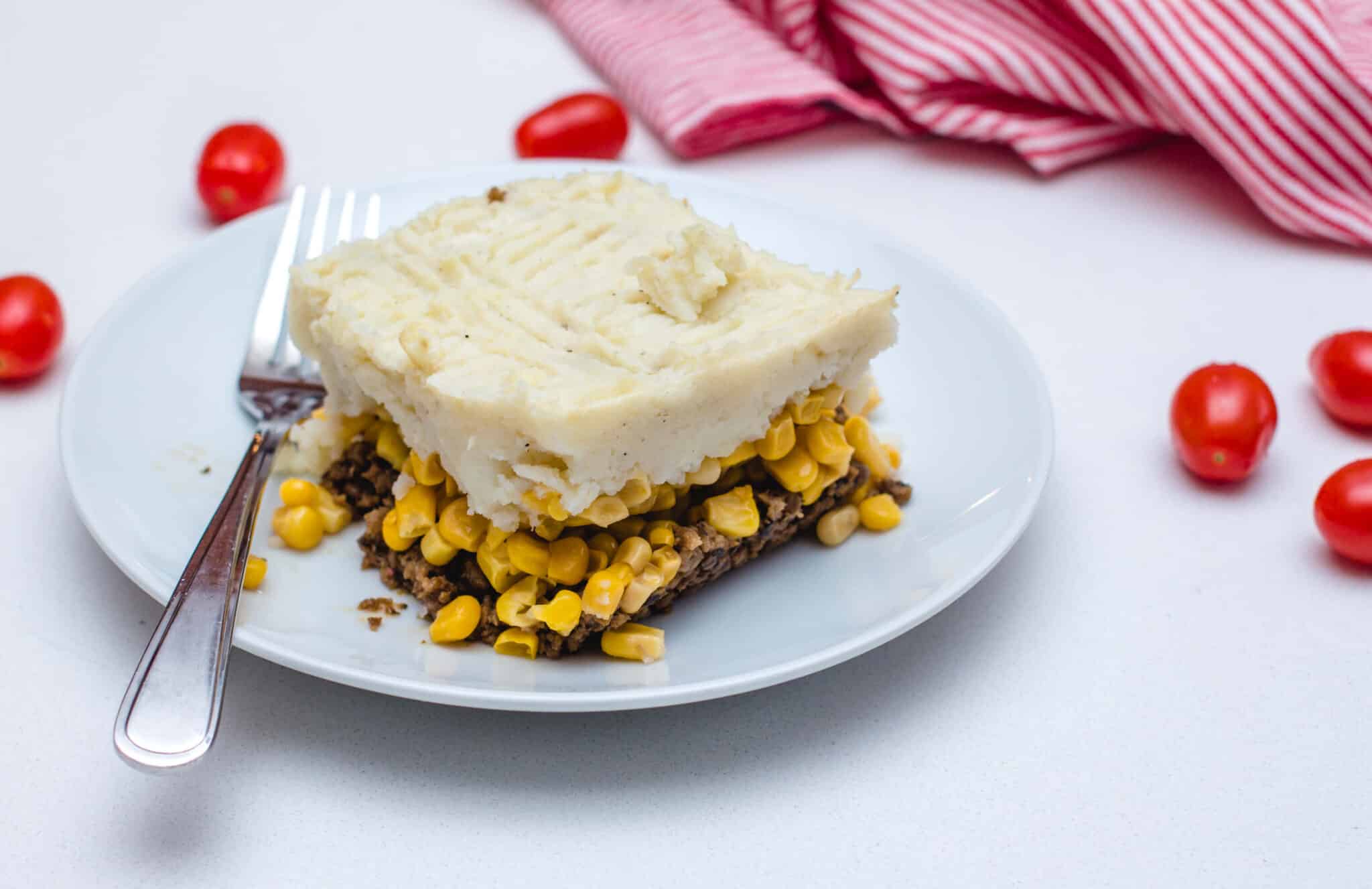 vegan lentil shepherd's pie being served on a white dish 