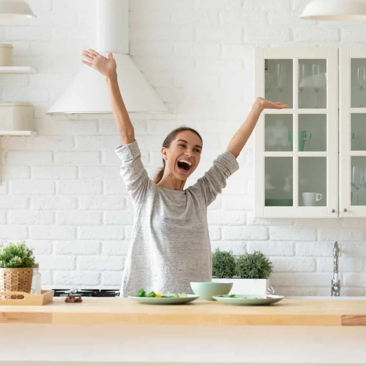 woman jumping for excitement in kitchen