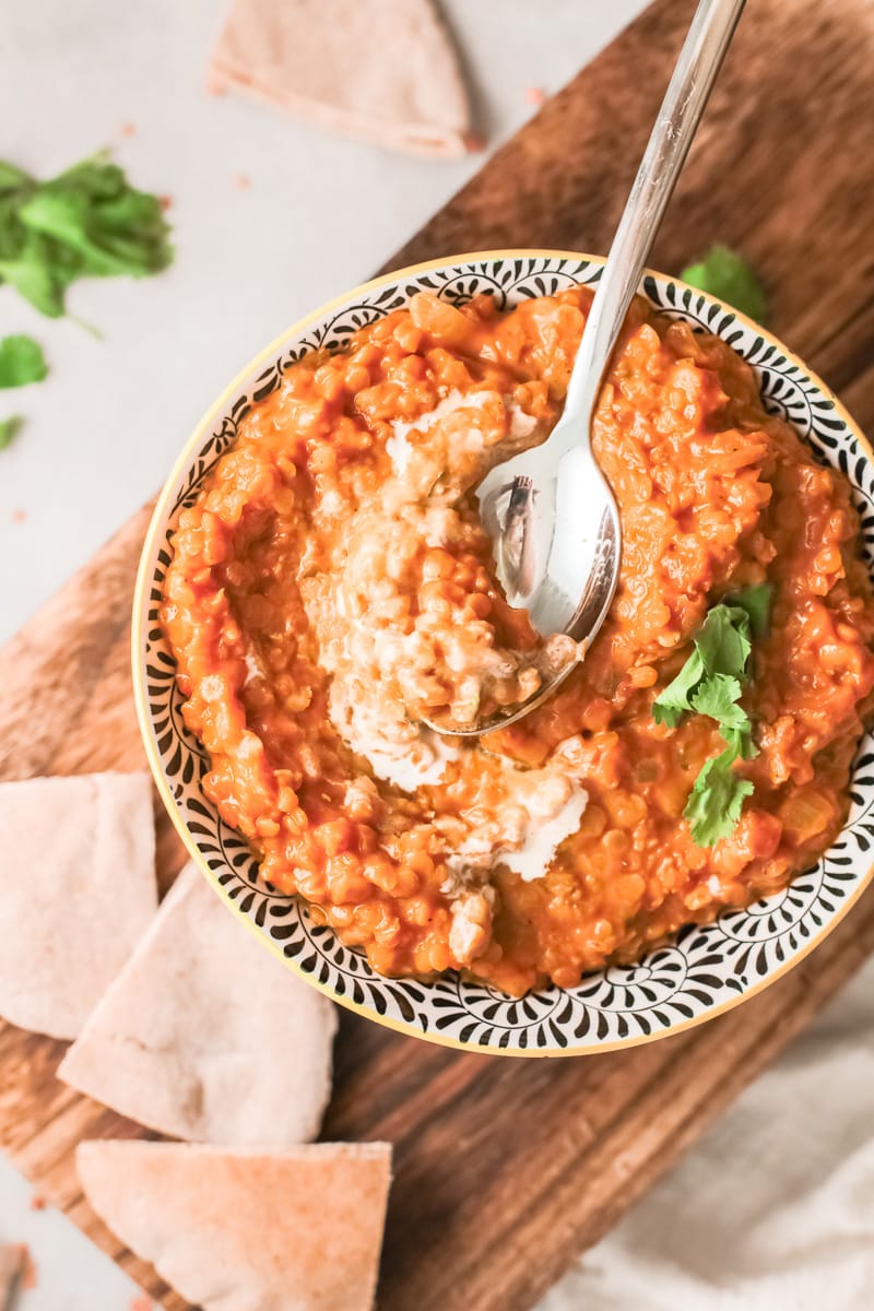 bowl of vegan red lentil curry with spoon