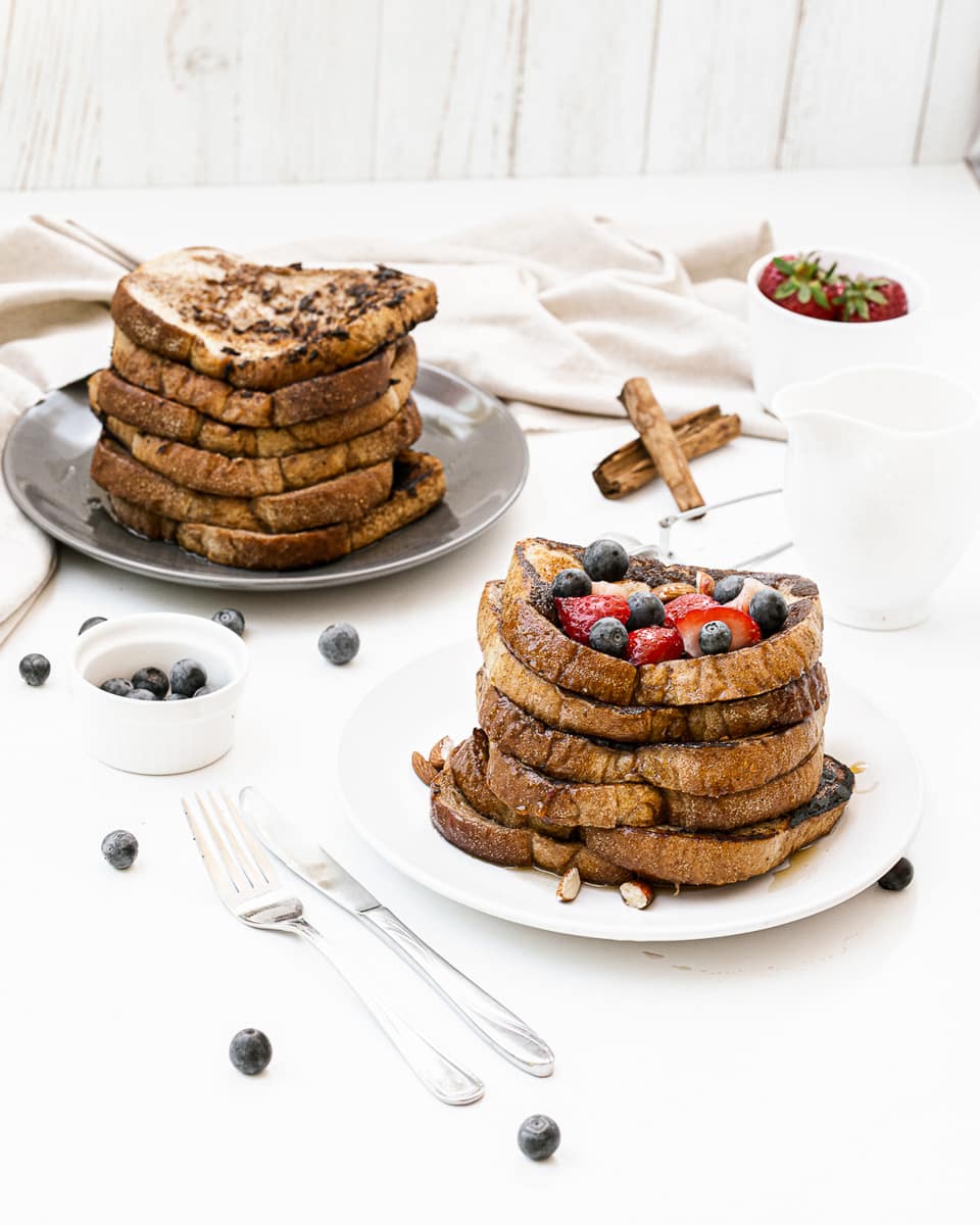 tall two stacks of vegan french toast on white plates