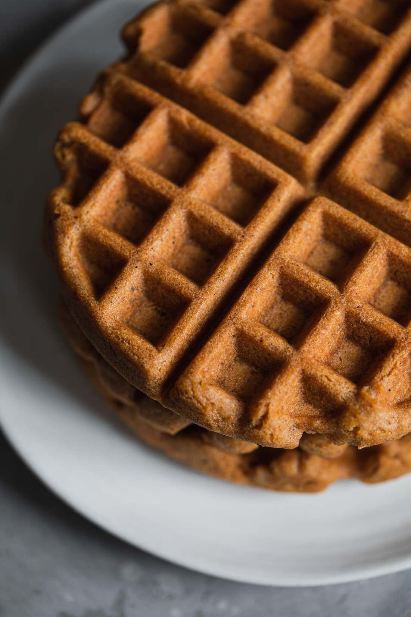 stack of gingerbread waffles on a white plate