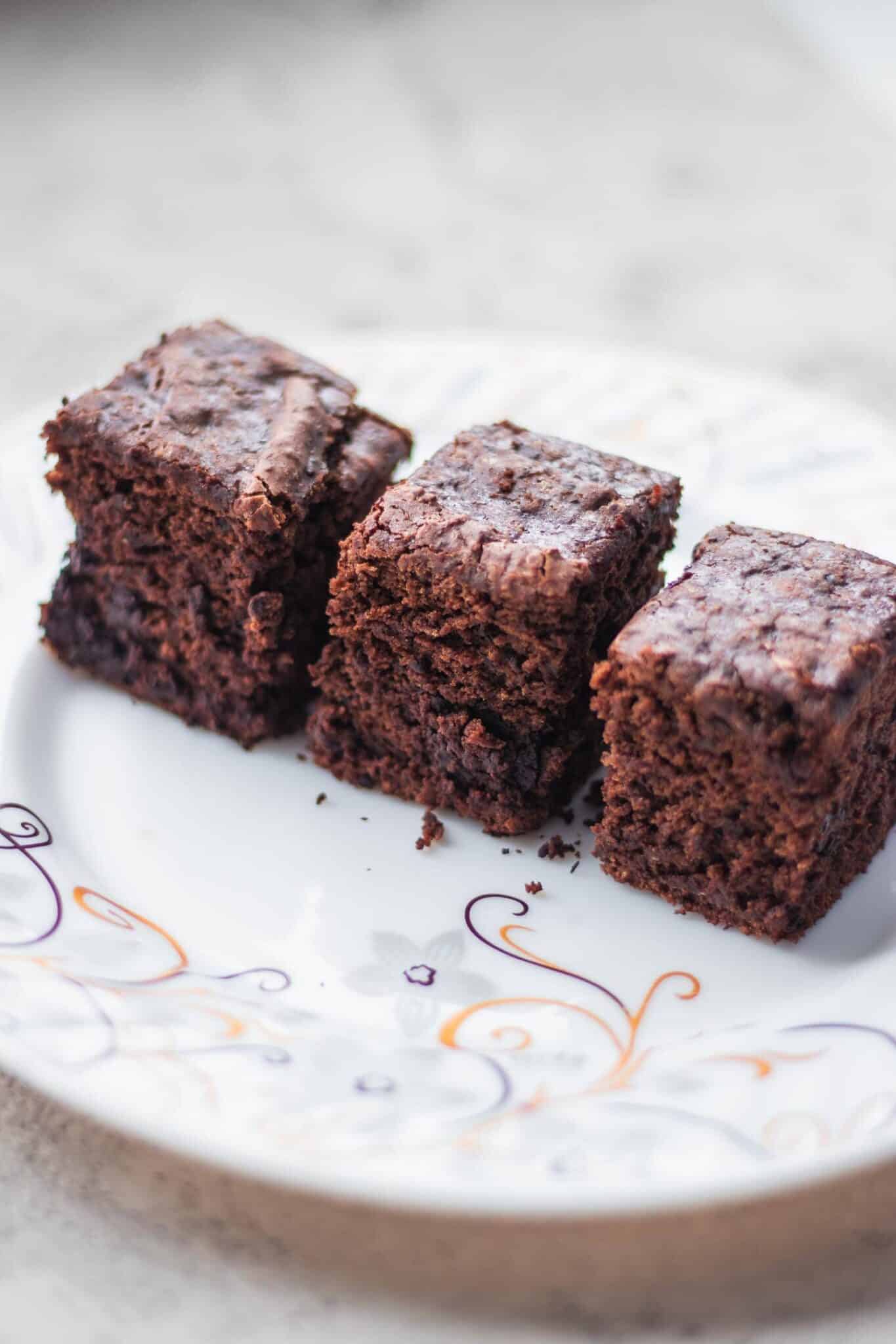 vegan brownies lined up on a white plate