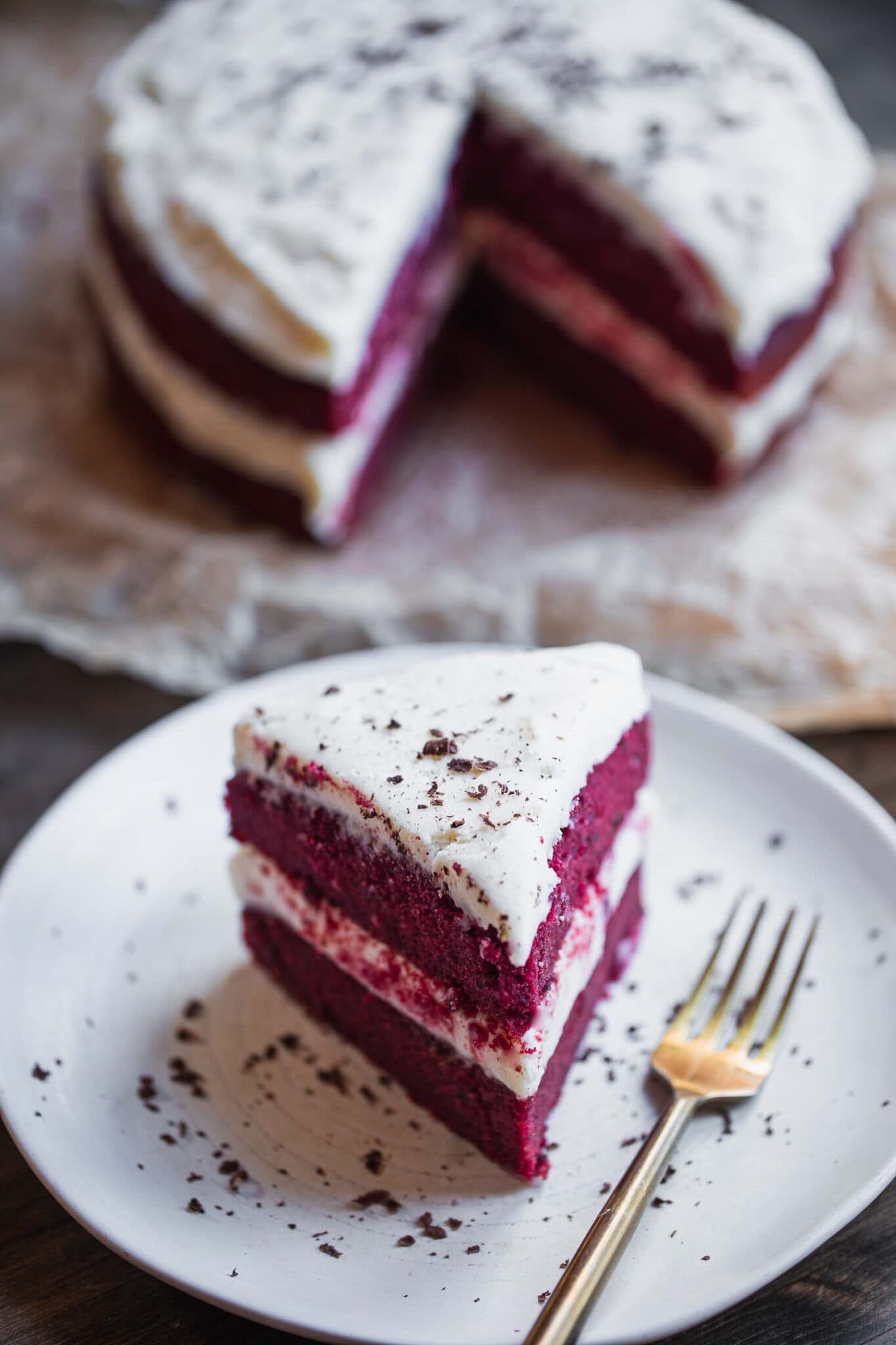 a slice of vegan red velvet cake ready to be eaten