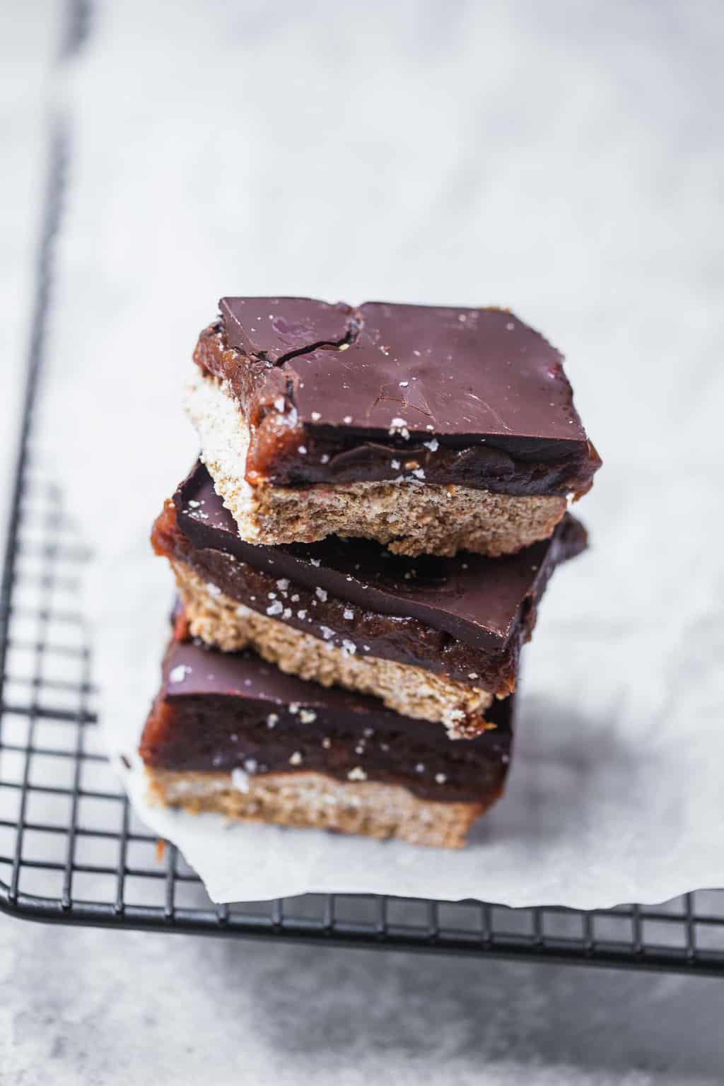 vegan millionaire shortbread pieces stacked on a cooling rack