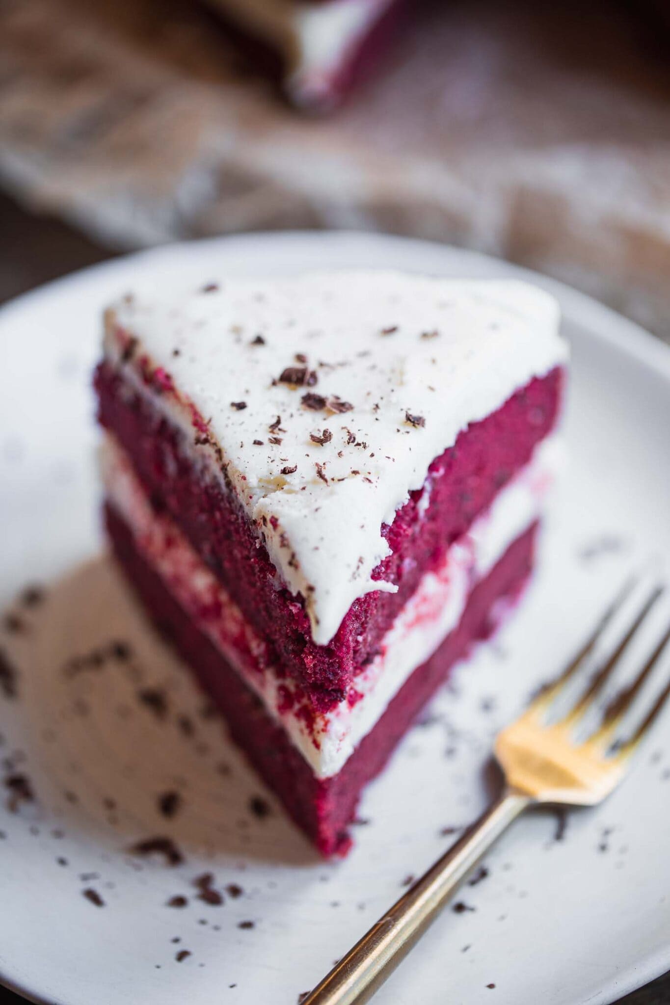 a slice of vegan red velvet cake with a fork