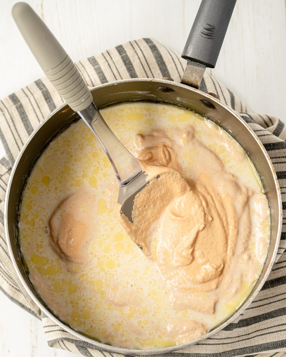 stirring vegan queso ingredients in pot