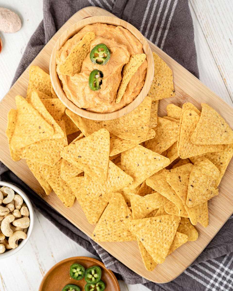 vegan queso on serving board with chips