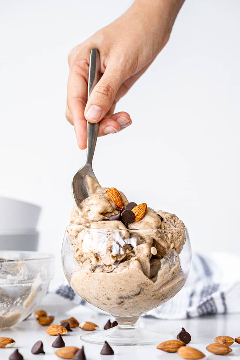 spoon digging into glass of almond milk ice cream