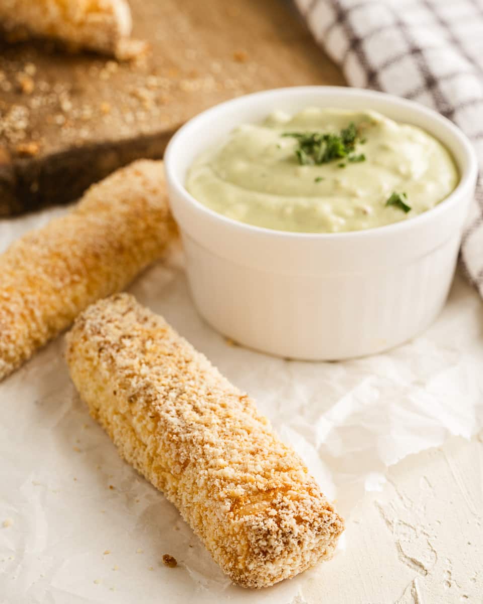 sticks of fried halloumi with jar of avocado dip