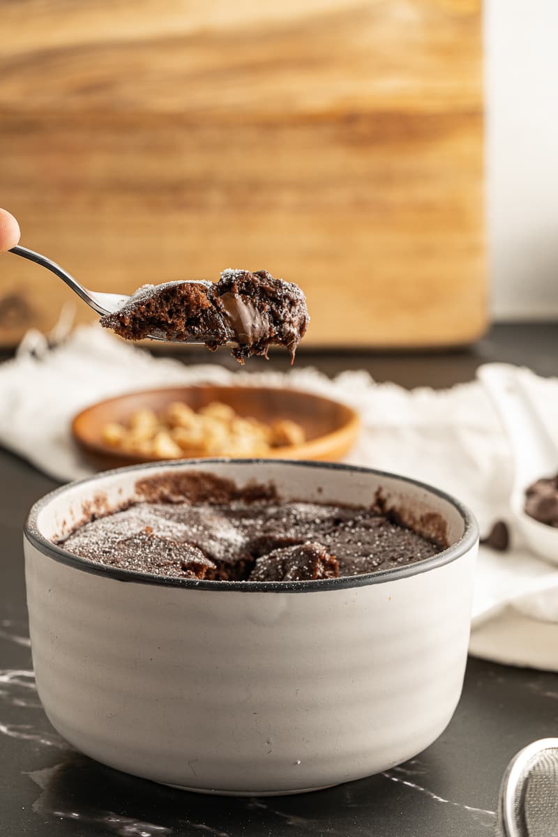 scooping a spoonful out of a brownie mug cake