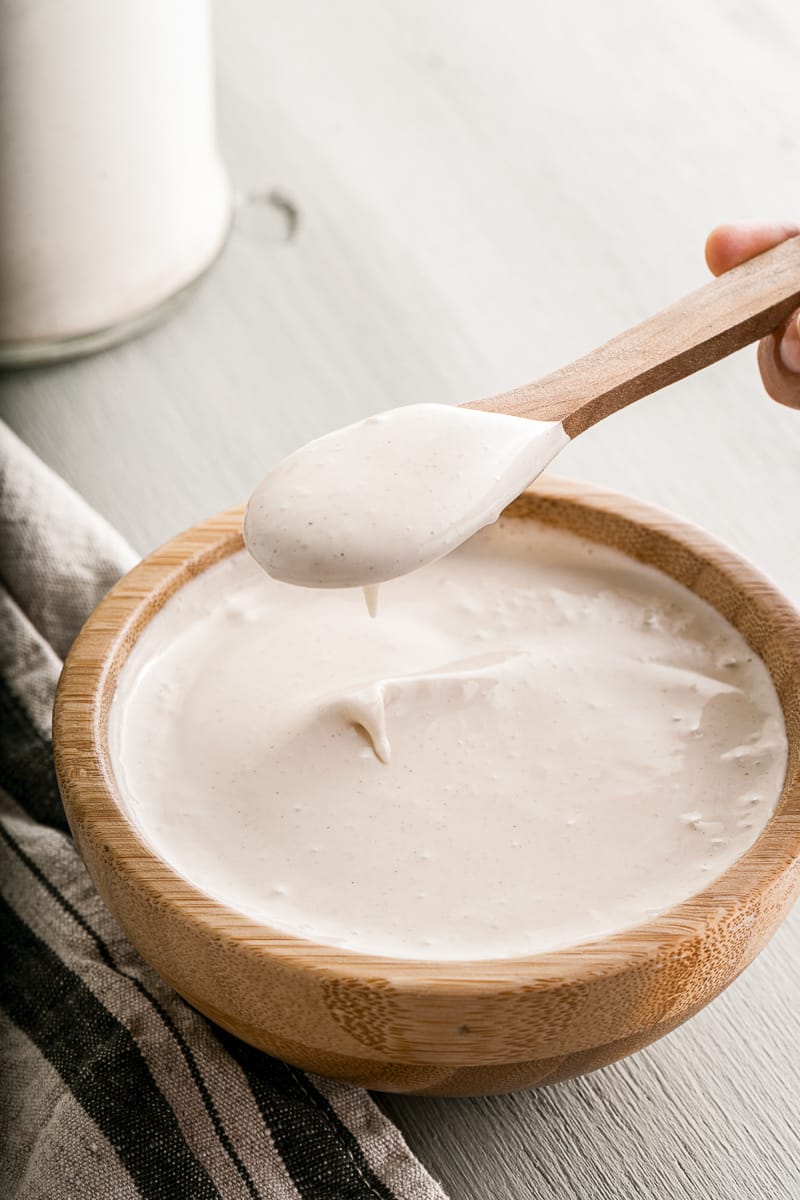 scooping a spoonful out of a bowl of easy vegan mayo