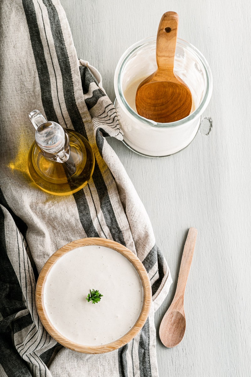 top view of oil, mixing jar, & serving bowl with easy vegan mayo inside