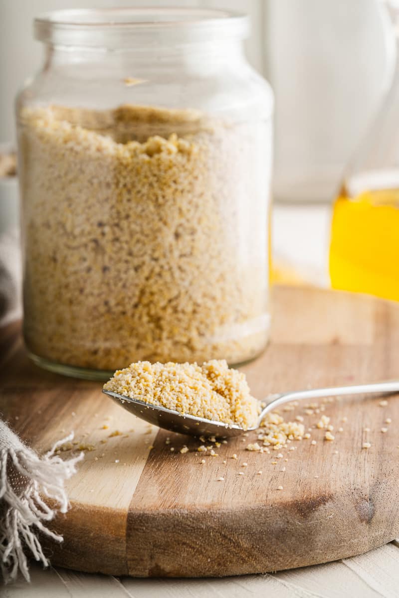 spoonful of vegan parmesan next to jar full