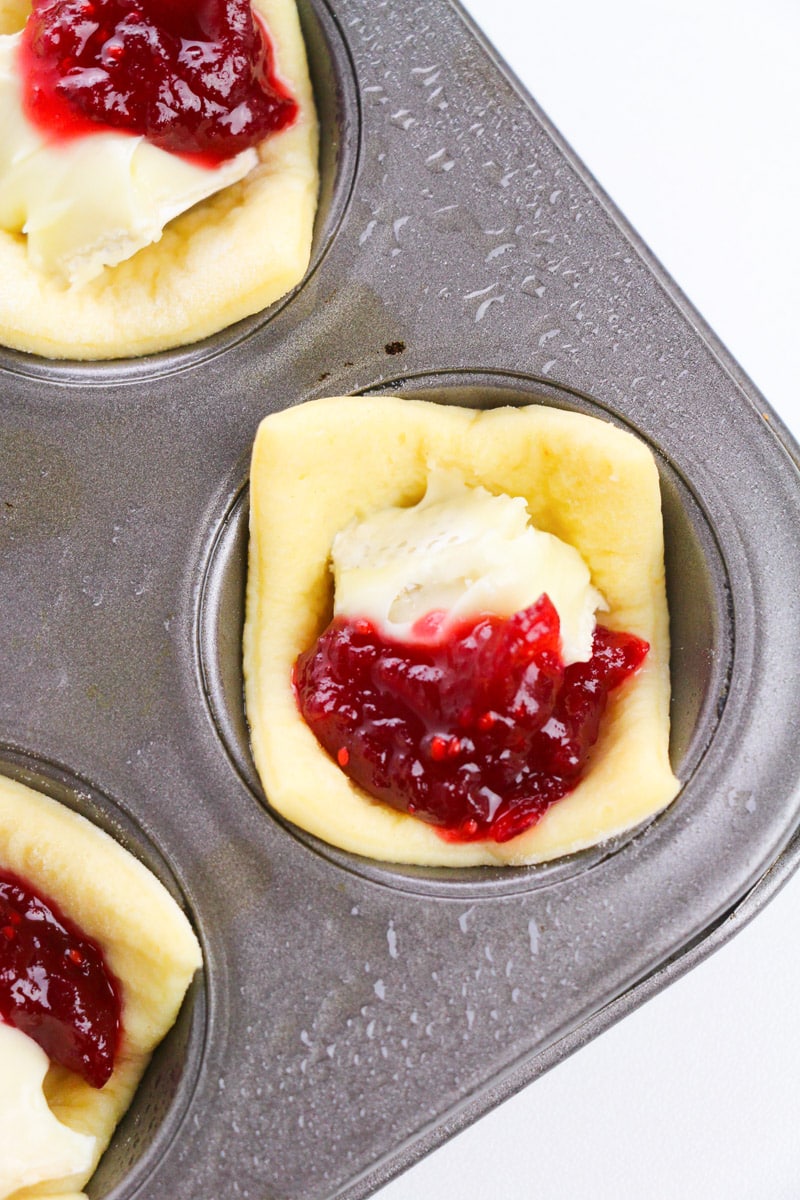 close up unbaked cranberry brie bites in a muffin tin