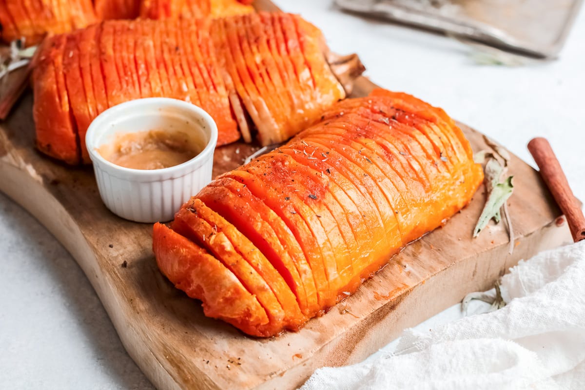 side view  of hasselback butternut squash on a wooden board