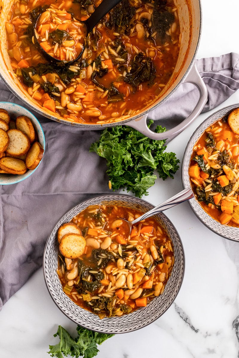 bowl of White Bean Kale Soup next to pot