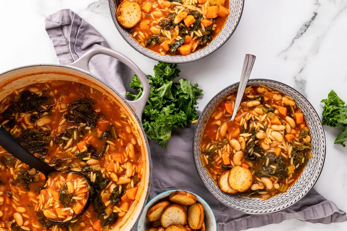 two bowls and pot of White Bean Kale Soup