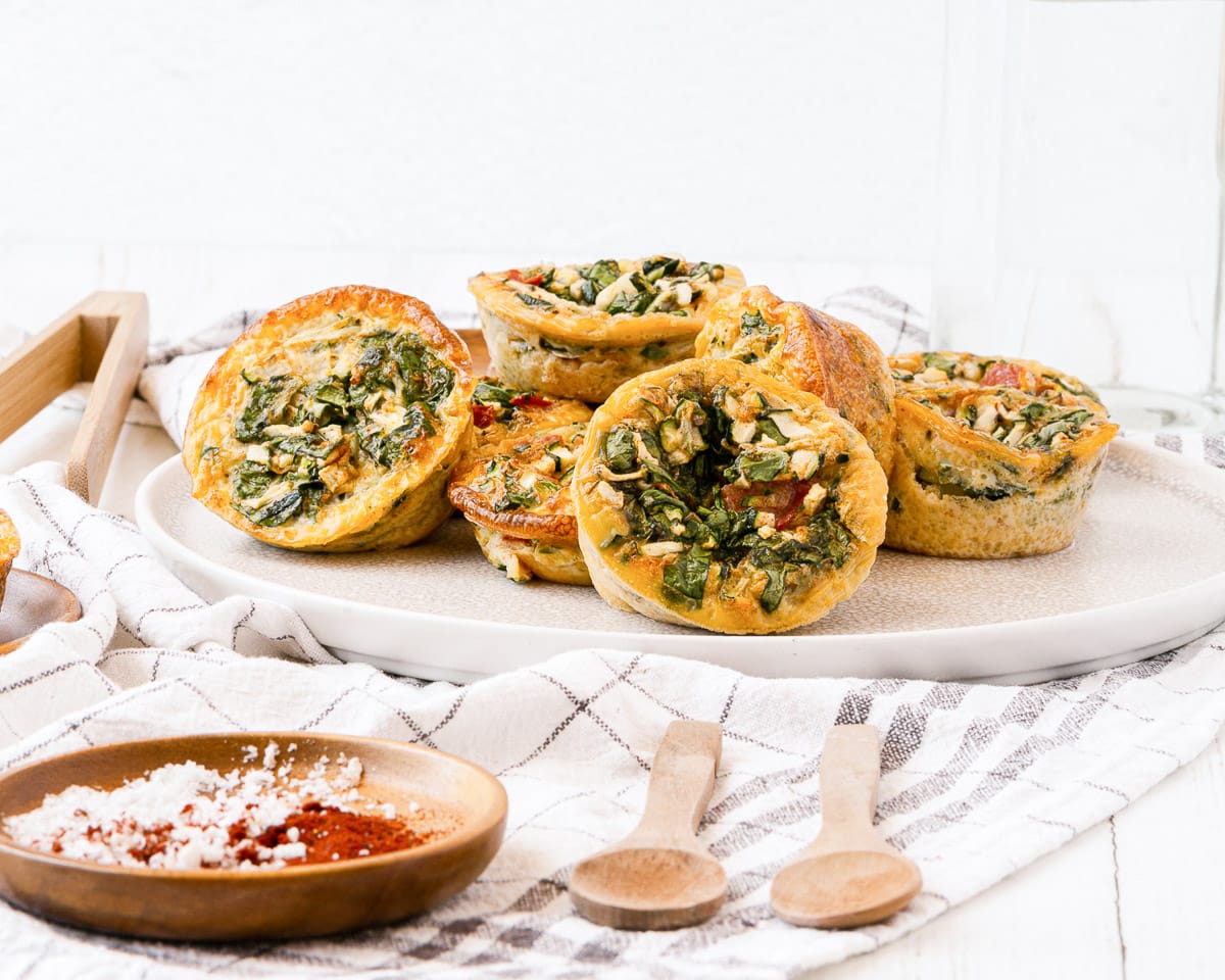 large plate of muffin tin egg bites next to plate of spices