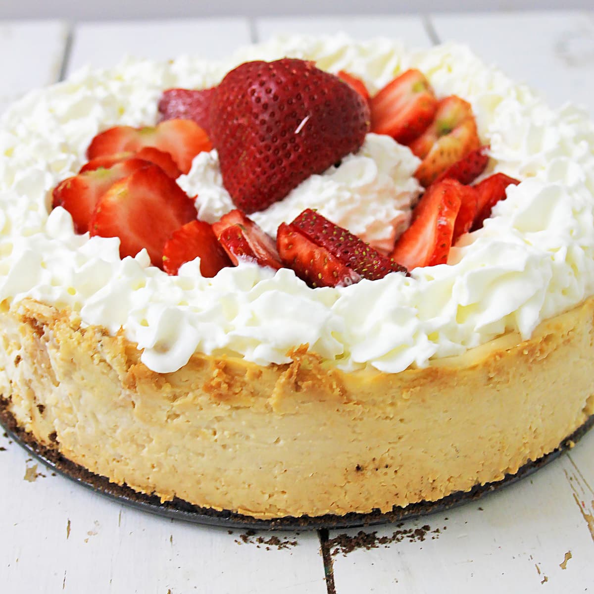 the best vegan cheesecake topped with whipped topping and strawberries