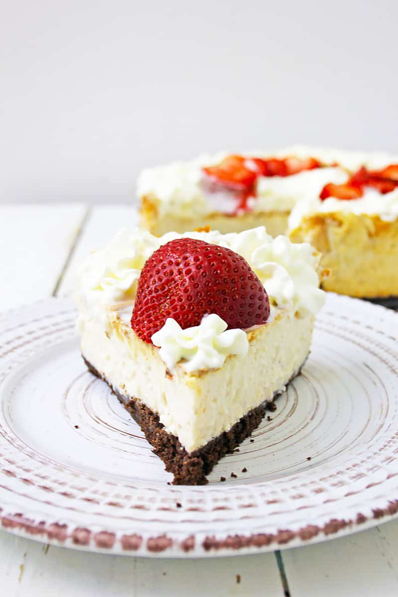 slice of the best vegan cheesecake with large strawberry on top