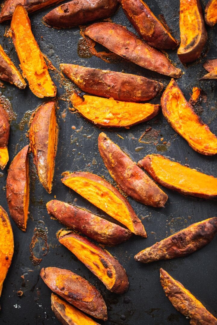 Baked sweet potato wedges on a baking tray