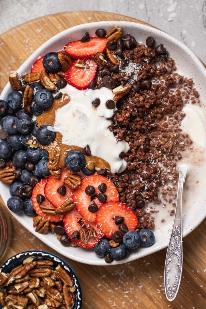 Bowl of chocolate porridge with soy yoghurt, berries and peanut butter